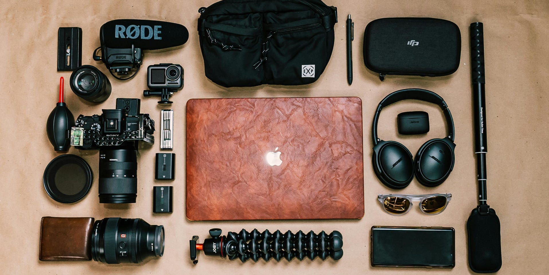 Overhead view of laptop and photo camera composed with headphones and other gadgets of professional photographer
